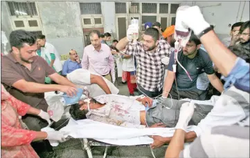  ?? — Reuters photo ?? Hospital staff move a stretcher with an injured man after a commuter train struck a crowd on rail tracks in Amritsar, India.