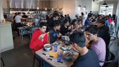  ?? PHOTOS BY JIM GENSHEIMER ?? Ben Richardson, 15, of Cupertino pulls up noodles from his bowl as he eats ramen with friends at Afuri.