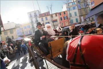  ?? (Photos Frank Muller) ?? A bord d’une magnifique calèche, le Père Noël a descendu le cours Louis-Blanc puis a sillonné les rues du centre ancien, n’hésitant pas à mettre pied à terre pour poser en photo avec les enfants.