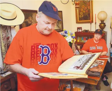  ?? GREG SORBER/ JOURNAL ?? Boston Red Sox fan, John Abele, left, looks at a scrapbook belonging to Mary Sarty, the daughter of former Red Sox pitcher Pinky Woods.