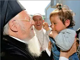  ??  ?? El patriarca ecuménico Bartolomé levanta a un bebé mientras el papa Francisco lo observa sonriendo