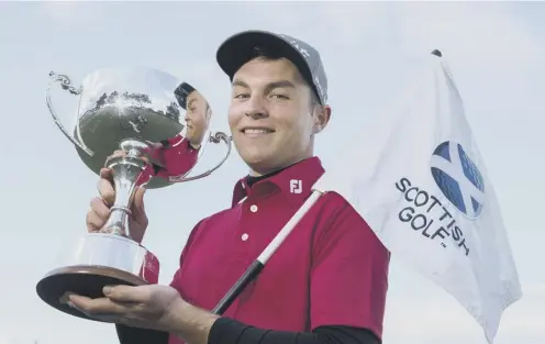  ??  ?? John Paterson poses with the trophy after winning the Scottish Boys’ Open Stroke-play Championsh­ip at Monifieth Links.