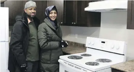  ??  ?? Husband and wife, Abdulahi Wozir, left, and Nebat Mohamed, receive the keys for their first home at the Carter Place developmen­t site Thursday, courtesy of Habitat for Humanity and the Jimmy & Rosalynn Carter Work Project. The couple moves into their...