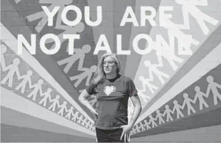  ?? TRAVIS HEYING The Wichita Eagle ?? Abi Boatman (she/her) stands in front of the Pride mural at Reverie Roasters coffee shop in Wichita. Boatman is an Air Force veteran, small business owner and a transgende­r Kansan.