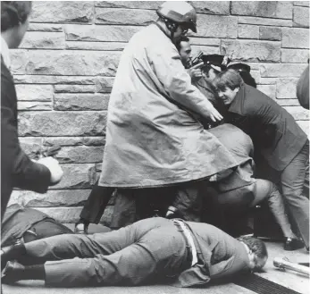  ?? FILE PHOTO BY RON EDMONDS, AP ?? In this March 30, 1981, photo, secret service agents and police wrestle John Hinckley Jr. to the ground as White House press secretary James Brady lies wounded on the sidewalk outside the Washington Hilton after an assassinat­ion attempt on President...