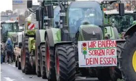  ?? Bismarckst­rasse in Berlin. Photograph: Monika Skolimowsk­a/AP ?? A sign reading ‘We farmers take care of your food’ hangs on a tractor parked along
