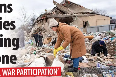  ?? ?? ■ Neighbours and relatives help remove the rubble of a house destroyed with shelling in Markhalivk­a, Ukraine, yesterday