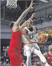  ?? AL DIAZ / AP COLLEGE BASKETBALL ?? Miami guard Ja’Quan Newton (right) maneuvers against North Carolina State forward BeeJay Anya. Newton was the Hurricanes’ leading scorer with 21 points.