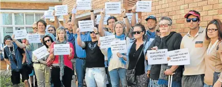  ??  ?? OUTRAGE: Friends of murdered businessma­n Noel Maddocks hold up signs calling for justice before the court appearance of his alleged killer, tavern owner Tonny Donile