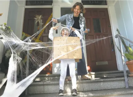  ?? Liz Hafalia / The Chronicle ?? Jessica Vinocour and her 5yearold son Luca play with a spider web as they decorate their home in San Francisco.