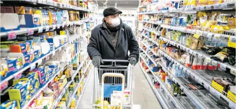  ?? ARCHIVFOTO: KAY NIETFELD/DPA ?? Ein Kunde kauft mit Mundschutz und Handschuhe­n in einem Berliner Supermarkt ein. In Ravensburg gibt es kaum Kunden, die sich auf diese Weise vor Ansteckung schützen.