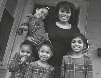  ?? ASSOCIATED PRESS ?? DINORA TORRES, A MASSBAY COMMUNITY COLLEGE STUDENT, poses with her four daughters on the front porch of their home on Jan. 14 in Milford, Mass. From front left are daughters Davina, Alana and Hope, with Faith in Dinora’s arms. At the college, applicatio­ns for meal assistance scholarshi­ps have increased 80% since last year. Among the recipients is Torres, who said the program helped keep her enrolled.