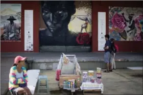  ?? RENATA BRITO — THE ASSOCIATED PRESS ?? In this photo, tourists look at murals in the renovated port area in Rio de Janeiro, Brazil. A new app called “Museum of Yesterday” seeks to educate visitors about the history and role of Rio de Janeiro’s revitalize­d port in colonizati­on, slavery and...