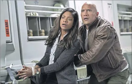  ?? BROS. PICTURES ?? Dr. Kate Caldwell (Naomie Harris) and Davis Okoye (Dwayne Johnson) are having trouble believing what they’re seeing. WARNER