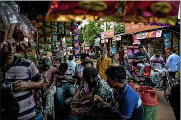  ?? ATUL LOKE — THE NEW YORK TIMES ?? Garment factory workers get together after their shift in Dhaka, Bangladesh, in July 2023. The country built its success on turning farmers into textile workers, but experts say that economic formula is slipping in a tech-driven world.