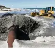  ?? FOTO: BERND WÜSTNECK / ZB ?? Über das Rohr wird Sand vom Meeresbode­n an den Strand gespült.