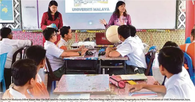  ??  ?? Teach For Malaysia fellow Kuan May Yin (left) and the Deputy Education Minister Teo Nie Ching (right) co-teaching Geography to Form Two students at SMK Pendamaran Jaya, Klang. The cover picture shows Kuan May Yin (standing, left) and Teo Nie Ching (sitting, second from left) taking a selfie with the students.