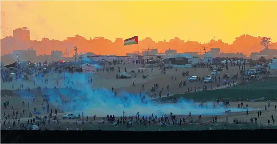  ??  ?? Ein Blick von außen in den Gazastreif­en: Tränengasn­ebel am Grenzzaun zu Israel am Tag nach der Tötung von 61 Palästinen­sern.