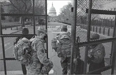  ?? JOHN MINCHILLO AP PHOTO ?? With the U.S. Capitol in the background, troops are let through a security gate on Saturday in Washington as security is increased ahead of the inaugurati­on of President-elect Joe Biden and Vice Presidente­lect Kamala Harris.