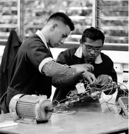  ?? AP ?? In this October 11, 2019, photo, José Fernando Guillén Rodríguez, 21 (left), practises building circuits with another student around a workbench in San Salvador, El Salvador. “I don’t think about migrating anymore,” said Rodríguez, who was apprehende­d in the US at 18 and spent time in adult detention before being deported. Now he’s completed a year of daily electrical classes and works as an apprentice at an electrical constructi­on company.