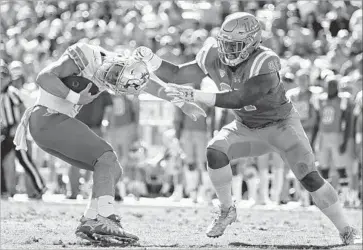  ?? Photograph­s by Robert Gauthier Los Angeles Times ?? JACOB TUIOTI-MARINER chases Ducks quarterbac­k Braxton Burmeister, who was sacked four times.