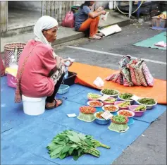  ??  ?? A vendor plying her ware at the Fresh Market.