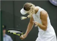  ?? BEN CURTIS — THE ASSOCIATED PRESS ?? Caroline Wozniacki shakes her head to avoid the flying insects on court during her women’s singles match against Ekaterina Makarova on the third day at the Wimbledon Tennis Championsh­ips in London, Wednesday.