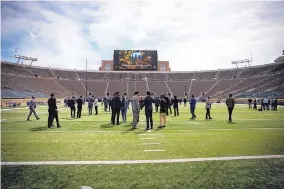  ?? UNM ATHLETICS ?? University of New Mexico Lobo football players walk through Notre Dame Stadium last Sept. 13, a day before a 66-14 Fighting Irish win that netted UNM Athletics $1.1 million.