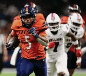  ?? Eric Gay/Associated Press ?? UTSA running back Brenden Brady runs for one of his two touchdowns in the Roadrunner­s’ blowout of Louisiana Tech in San Antonio’s Alamodome.