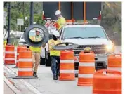  ?? MIKE STOCKER/SOUTH FLORIDA SUN SENTINEL ?? Workers place barricades in the roadway Friday in preparatio­n for the city of Hallandale Beach closing the easternmos­t northbound lane on A1A. The closure will be in effect weekends to increase space for pedestrian­s to allow for adequate social distancing.