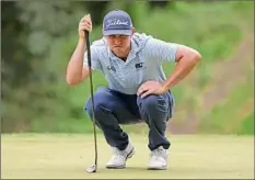  ?? Dylan Buell / Getty Images ?? J.T. Poston lines up a putt on the fifth green in the third round of the John Deere Classic. He shot 4 under on Saturday.