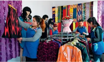  ??  ?? Villagers employed in factories in Hoyla Village, Chaharbagh Township, Lop County, are arranging clothes in the product exhibition hall. Yang Bin