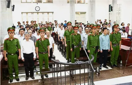  ??  ?? Facing the law: Tham (second from right) and Son (second from left) standing in a Hanoi court on the final day of their trial. — AFP