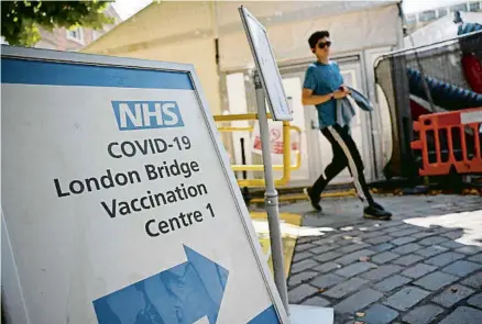 ?? TOLGA AKMEN / AFP ?? Cartells a l’entrada del centre de vacunació del pont de Londres