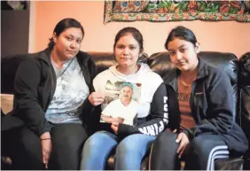  ?? BRYON HOULGRAVE/USA TODAY NETWORK ?? Maria Andrade of Marshallto­wn holds a photo of her father, Jose Andrade-Garcia, a meatpackin­g worker at a JBS plant Marshallto­wn, Iowa, who died of COVID-19 in May.