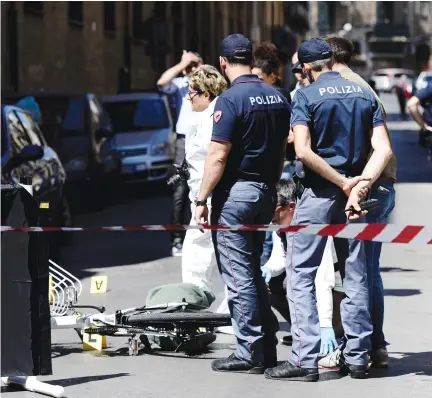  ?? (Guglielmo Mangiapane/Reuters) ?? ITALIAN POLICE OFFICERS stand on the site where mafia boss Giuseppe Dainotti was shot to death while riding his bicycle in Palermo last month.