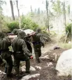  ?? ?? field dressing stations
Right: Soldiers carry a wounded comrade on a stretcher to one of the