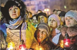  ?? DARKO BANDIC/AP ?? Supporters listen to former Ukrainian Prime Minister Yulia Tymoshenko as she addresses the crowd Saturday in central Kiev, Ukraine. Tymoshenko praised the demonstrat­ors killed in violence as heroes.