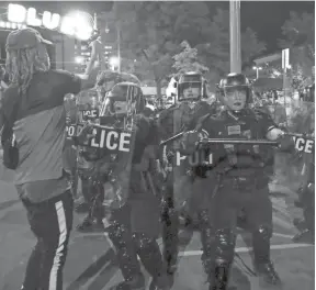  ?? HENRY TAYLOR/THE COMMERCIAL APPEAL ?? Police shove protesters away from where they are arresting a protester on Beale Street in Memphis on Sunday.