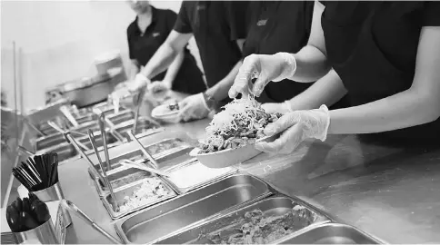  ??  ?? Employees prepare orders for customers at a Chipotle restaurant in Hollywood on July 16, 2013. — WP-Bloomberg photo