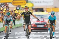  ?? THIBAULT CAMUS/ASSOCIATED PRESS ?? Britain’s Simon Yates, center, surrounded by Spain’s Pello Bilbao Lopez De Armentia, right, and Austria’s Gregor Muhlberger, celebrates as he crosses the finish line to win the mountainou­s 12th stage of the Tour de France on Thursday in Bagneres-de-Bigorre, France.