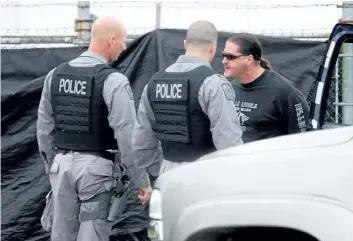  ?? MAGGIE RIOPELLE/ POSTMEDIA FILE PHOTO ?? Police seize the Hells Angels Niagara complex in this 2009 photo. Part owner Tim Panetta, right, was called to the facility, once police had a hold of the complex, to unlock the front gate and be served with the warrant.