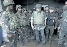  ?? THE ASSOCIATED PRESS ?? Philippine President Rodrigo Duterte, centre, congratula­tes the troops during a visit to the embattled Marawi city in southern Philippine­s on Thursday. Troops finally recaptured the main mosque where Islamic State-linked militants had taken cover with...