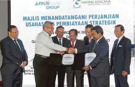  ?? PIC BY ZULFADHLI ZULKIFLI ?? Deputy Internatio­nal Trade and Industry Minister Datuk Seri Ahmad Maslan (centre) witnessing the exchange of documents between Affin Islamic chief executive officer (CEO) Nazlee Khalifah (second from right) and Gading Kencana managing director Datuk...