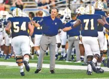  ?? STAFF PHOTO BY ROBIN RUDD ?? UT-Chattanoog­a head coach Rusty Wright congratula­tes offensive lineman after a successful extra point against Austin Peay in the 2021 season-opener for both team.