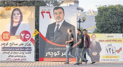  ?? AFP ?? Men walk along the side of a road past electoral banners for candidates running in the upcoming Iraqi elections in Zakho, in Iraq’s autonomous Kurdish region, yesterday.