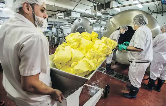  ?? PETER J THOMPSON / NATIONAL POST ?? Alliston Creamery employees churn and package Emerald Grasslands butter.