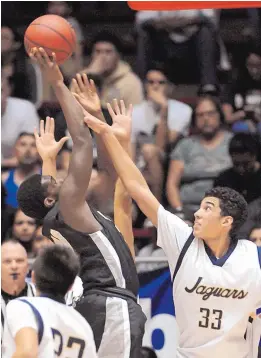  ?? JIM THOMPSON/JOURNAL ?? Volcano Vista’s Jalontae Gray takes a shot as Atrisco Heritage’s Jordan Arroyo (33) defends during Thursday night’s Class 6A boys semifinals game in the Pit.