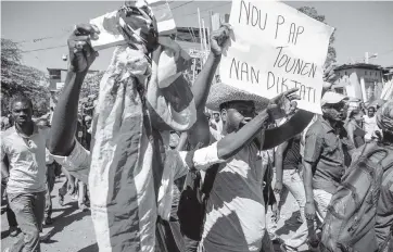  ?? VALERIE BAERISWYL AFP via Getty Images ?? Demonstrat­ors march in Port-au-Prince on Feb. 10.