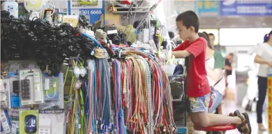  ?? (Jason Lee/Reuters) ?? A BOY does homework at a stall inside an electronic­s mall on Huaqiangbe­i Commercial Street, a marketplac­e for Chinese producers and internatio­nal wholesale buyers, in Shenzhen, last month.